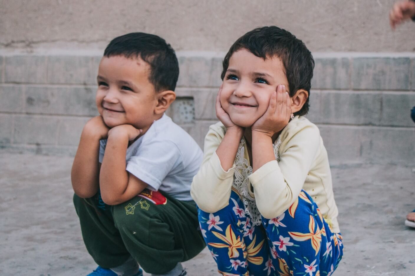 Children sitting, listening, and smiling
