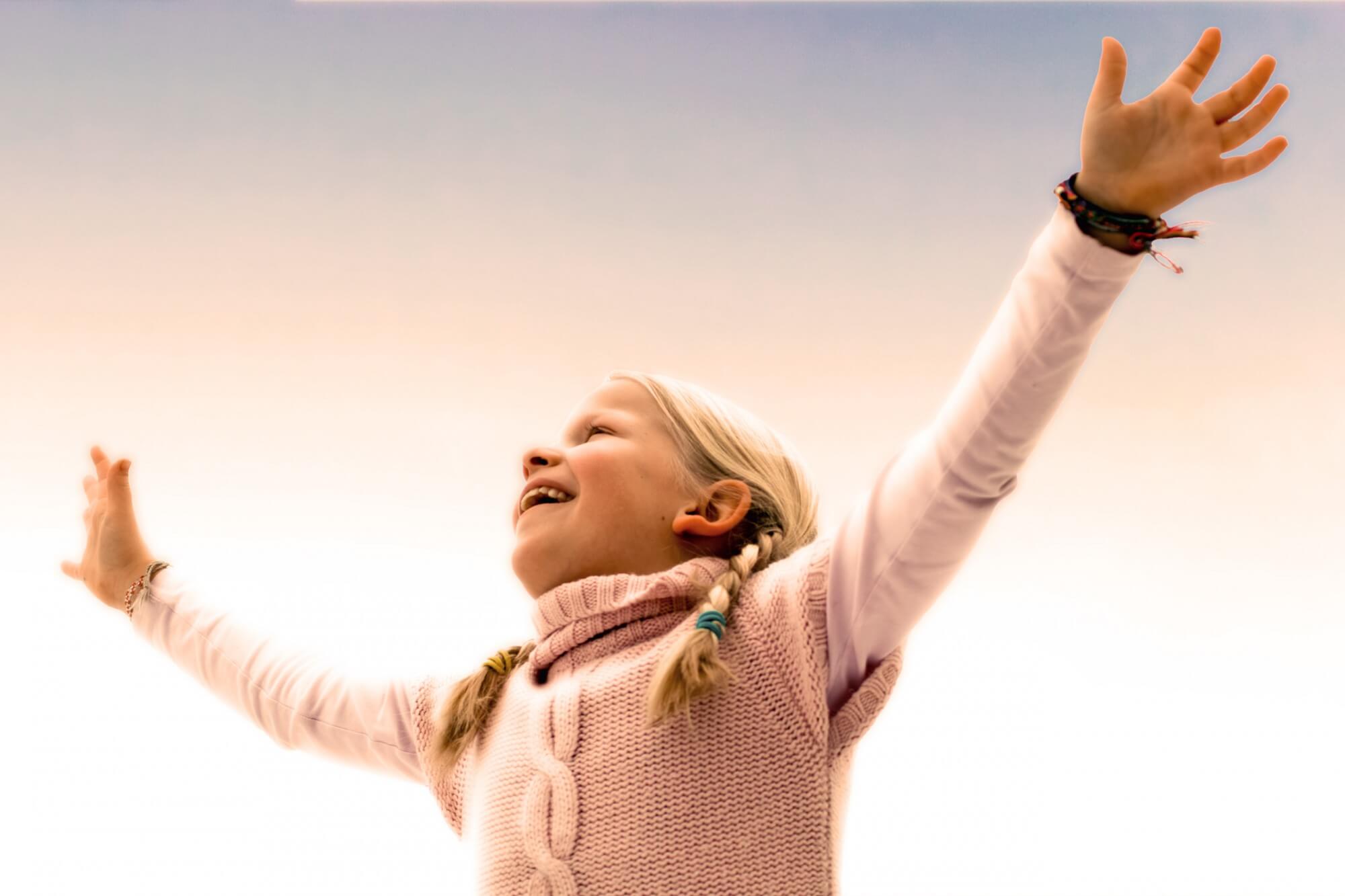 Child raising their arms up